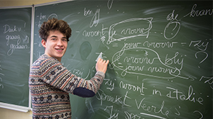Jonge leraar aan schoolbord