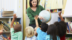 Leraar toont wereldbol aan multiculturele klas