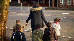 Juf met kleuters op de speelplaats