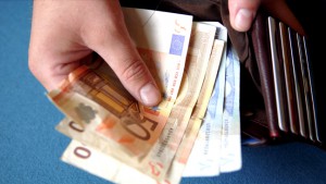 close up van hand die geld uit een portefeuille haalt