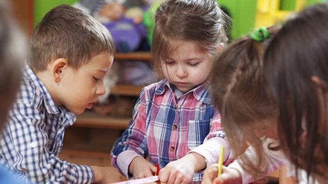drie kinderen in een kleuterklas