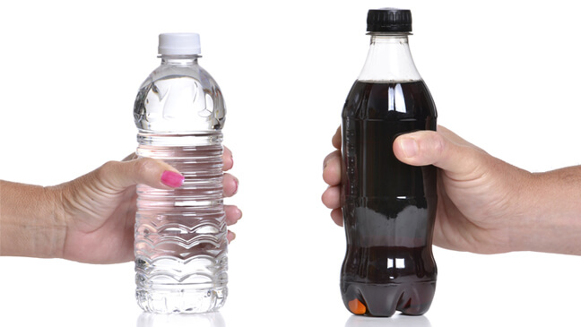 handen die een flesje water en een flesje cola vasthouden