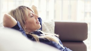 Jonge vrouw ligt ontspannen in de zetel