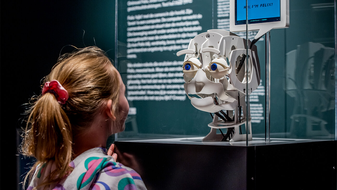 Meisje kijkt naar het hoofd van een robot