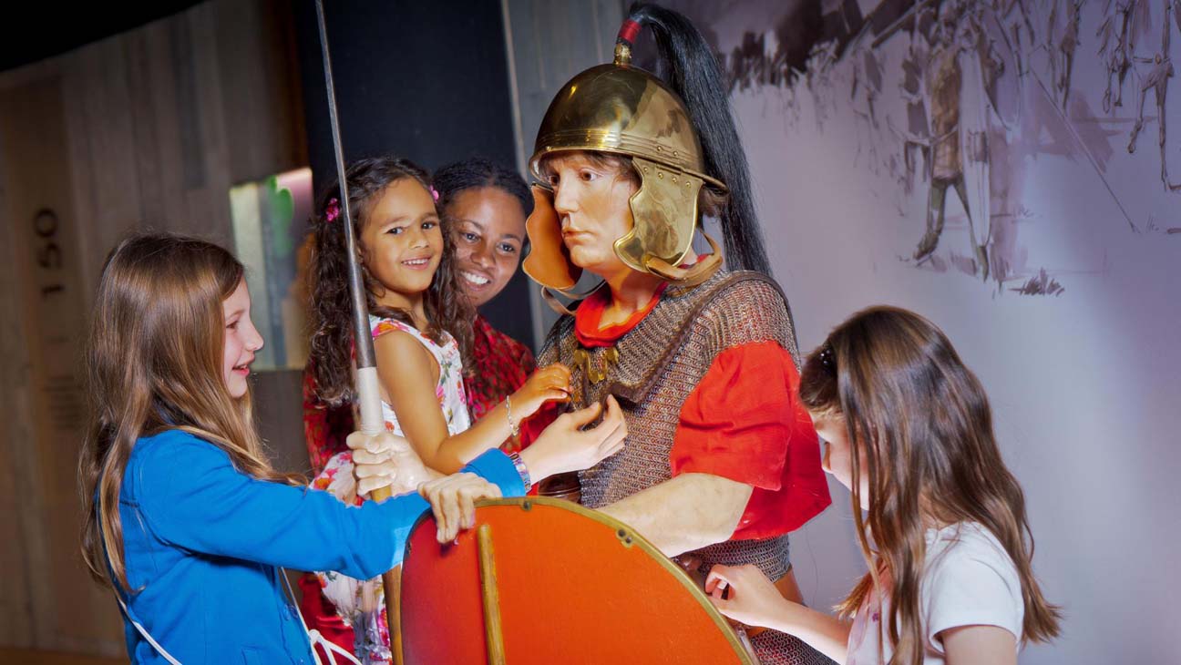 Kinderen kijken naar uniform Romeinse soldaat