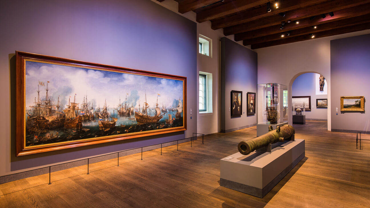 Binnenzicht museum met kanon en schilderijen