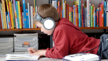 Jongen leest boek in Bibliotheek Dilbeek.