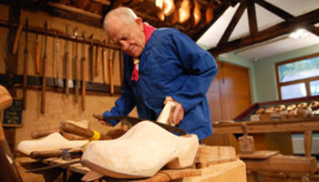 man maakt houten klomp