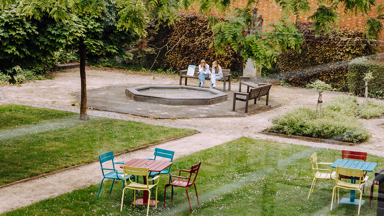 Bezoekers zitten op een bank in de tuin van het taxandriamuseum