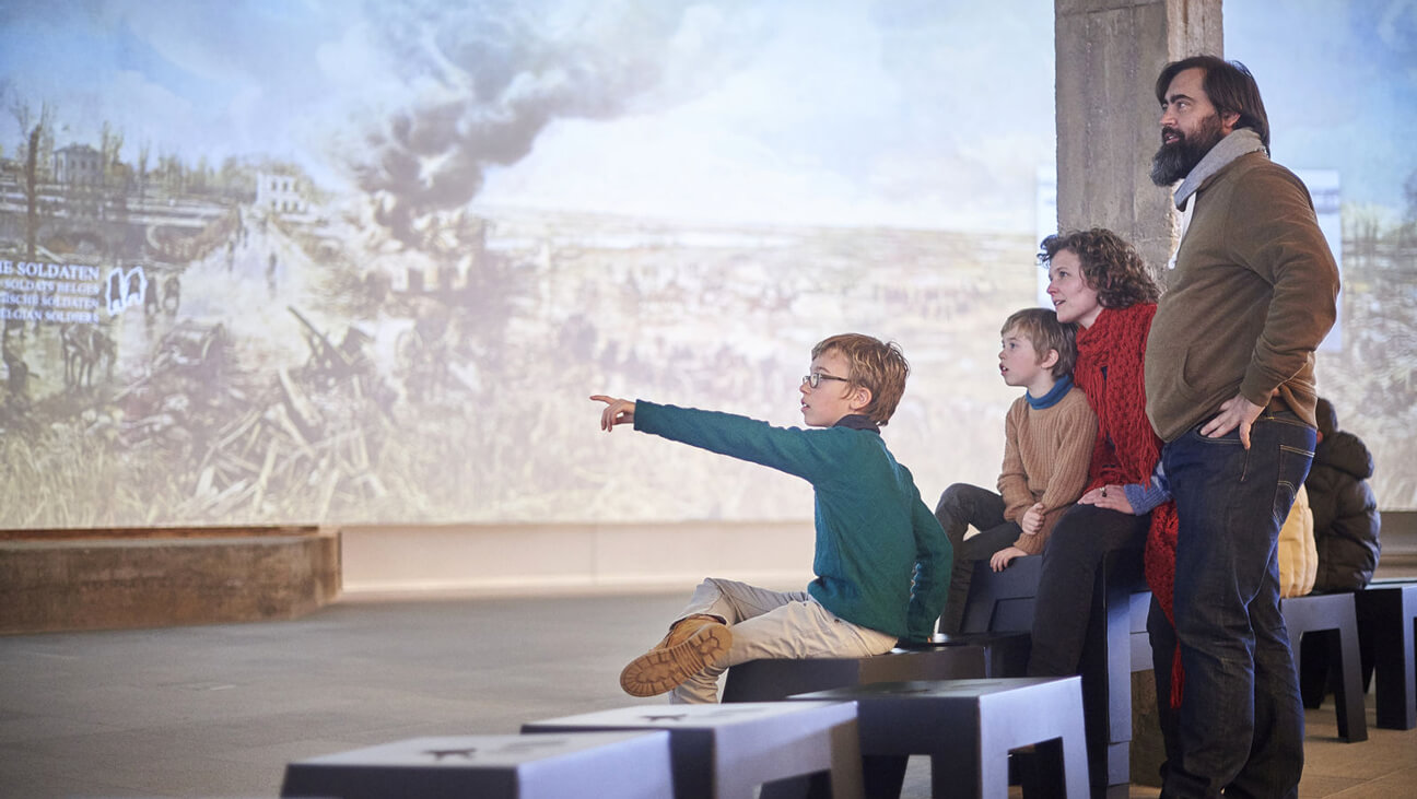 Gezin met kinderen kijken naar interactief scherm over WOI - Westfront Nieuwpoort