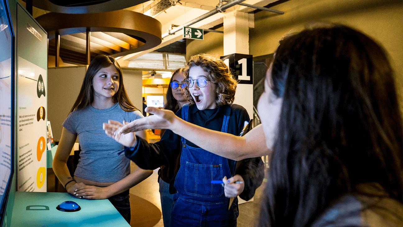 Jongeren kijken verrast naar een scherm in het ecohuis in Antwerpen