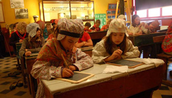Kinderen volgen les in traditionele kleding - Oud Schoolgebouw Sincfala