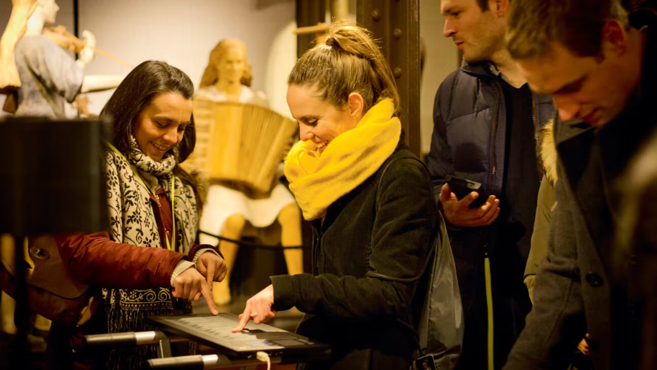 Bezoekers testen toetsenbord uit in het Muziekinstrumentenmuseum