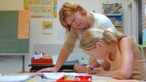 leraar helpt leerling in de klas
