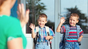 mama wuift kinderen uit aan schoolpoort