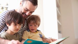 Vader en twee zoontjes lezen samen een boek