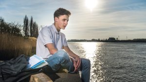 Jongen zit bij het water