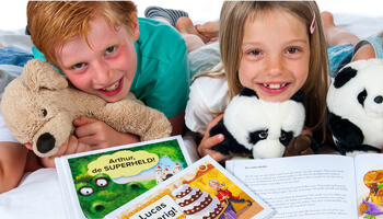 Kinderen poseren voor een stapel van boekjes met hun naam op de cover