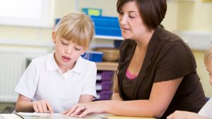 Leerkracht helpt meisje bij lezen
