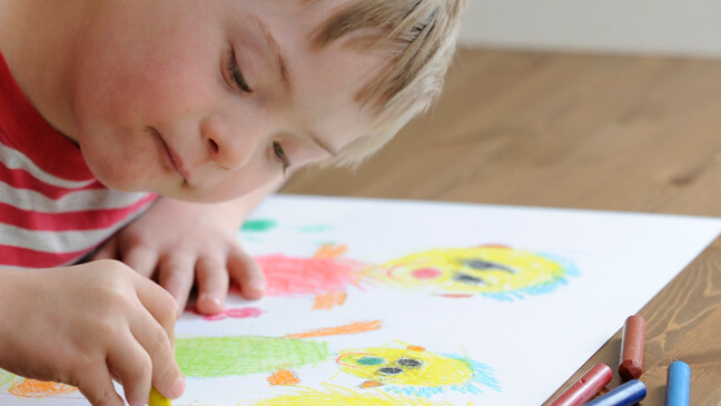 jongen met down aan het kleuren