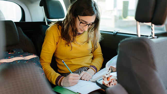meisje doet huiswerk in wagen