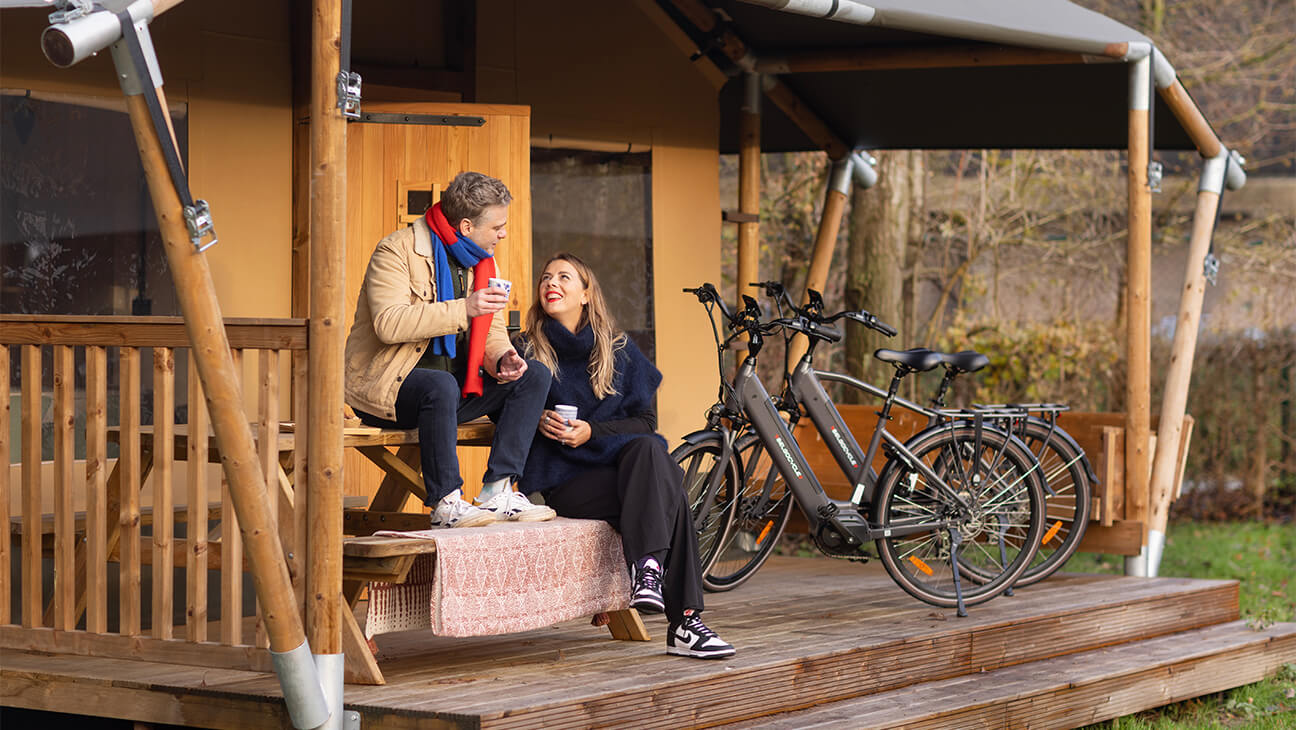 Koppel bij een glamping-tent met fietsen van Belgocycle