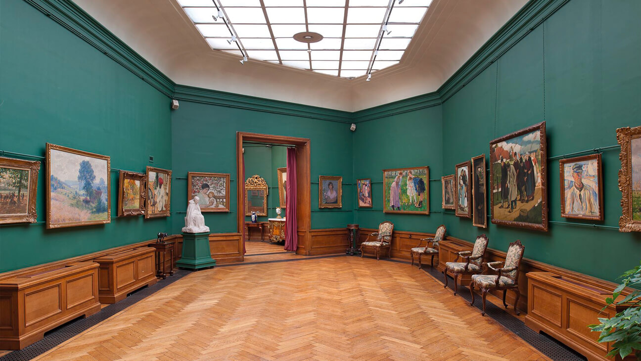 zaal in museum met schilderijen en meubels