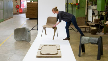 vrouw zet stoel klaar in museumopstelling