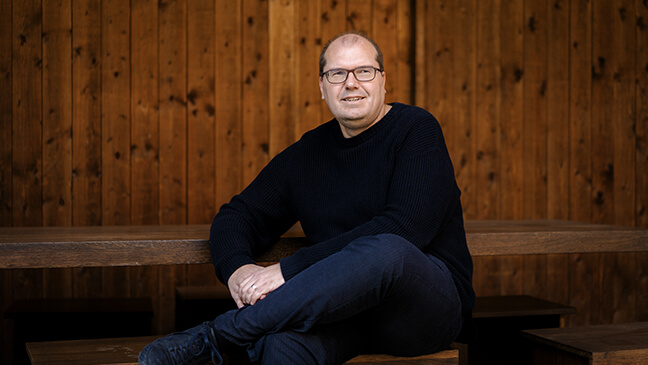 Architect Dimitri Minten zit op een bank.