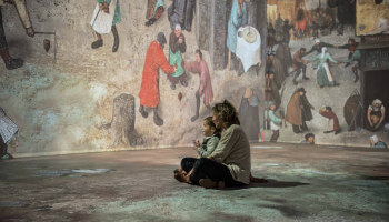 moeder met kind tussen projectie van schilderij van Bruegel