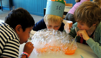 kinderen blazen bellen in zeepsop