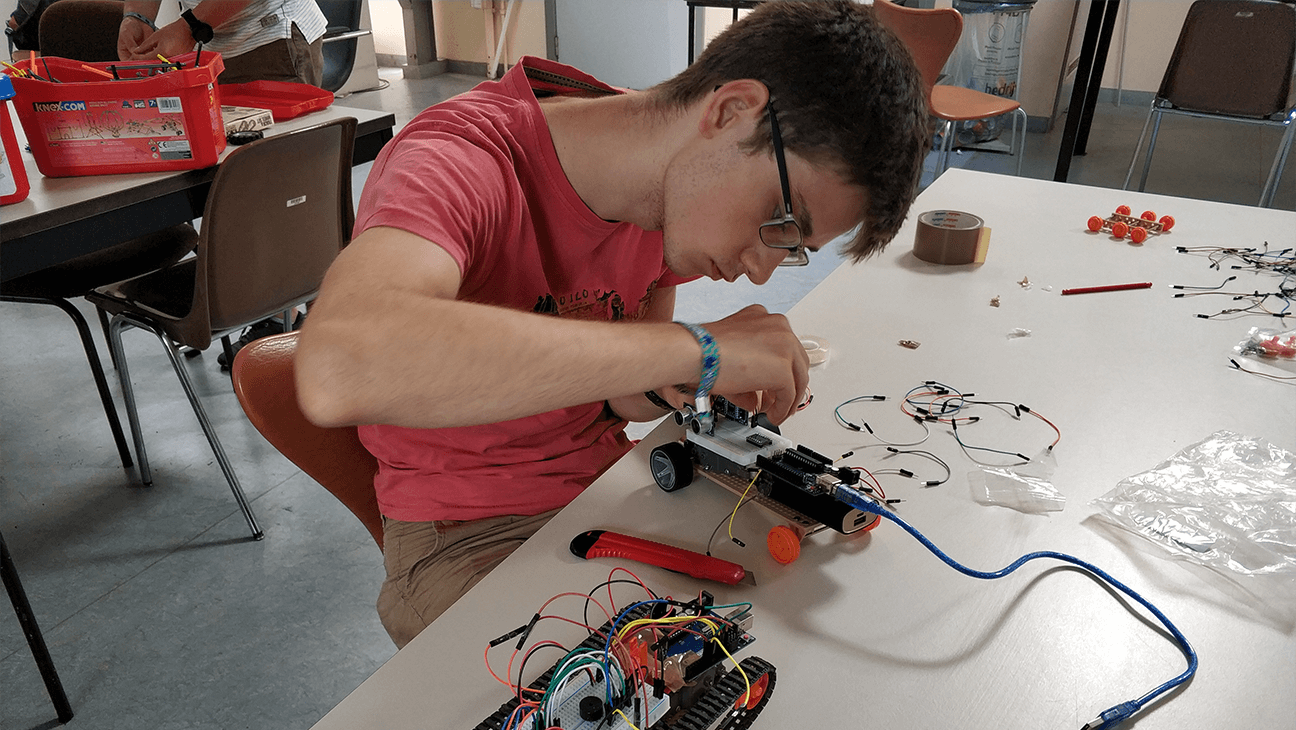 Jongen programmeert een zelfgebouwde robot