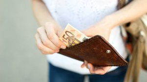 close up van hand die geld uit een portefeuille haalt