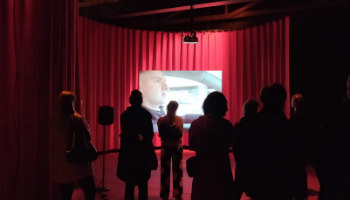 mensen kijken naar scherm in theaterzaal