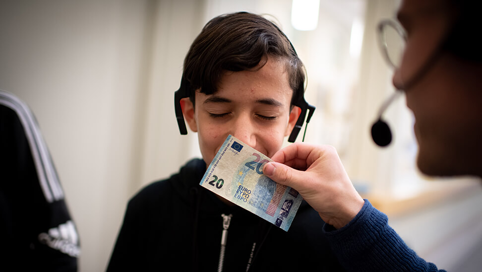 leerling mohamed ruikt aan een briefje van 20 euro