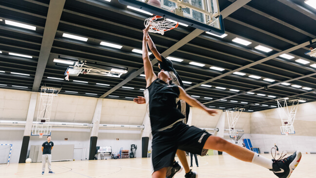 Jongeren spelen basketbal op de topsportschool
