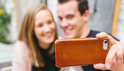 Mensen nemen een selfie met een gsm in een hoesje van Deejoux