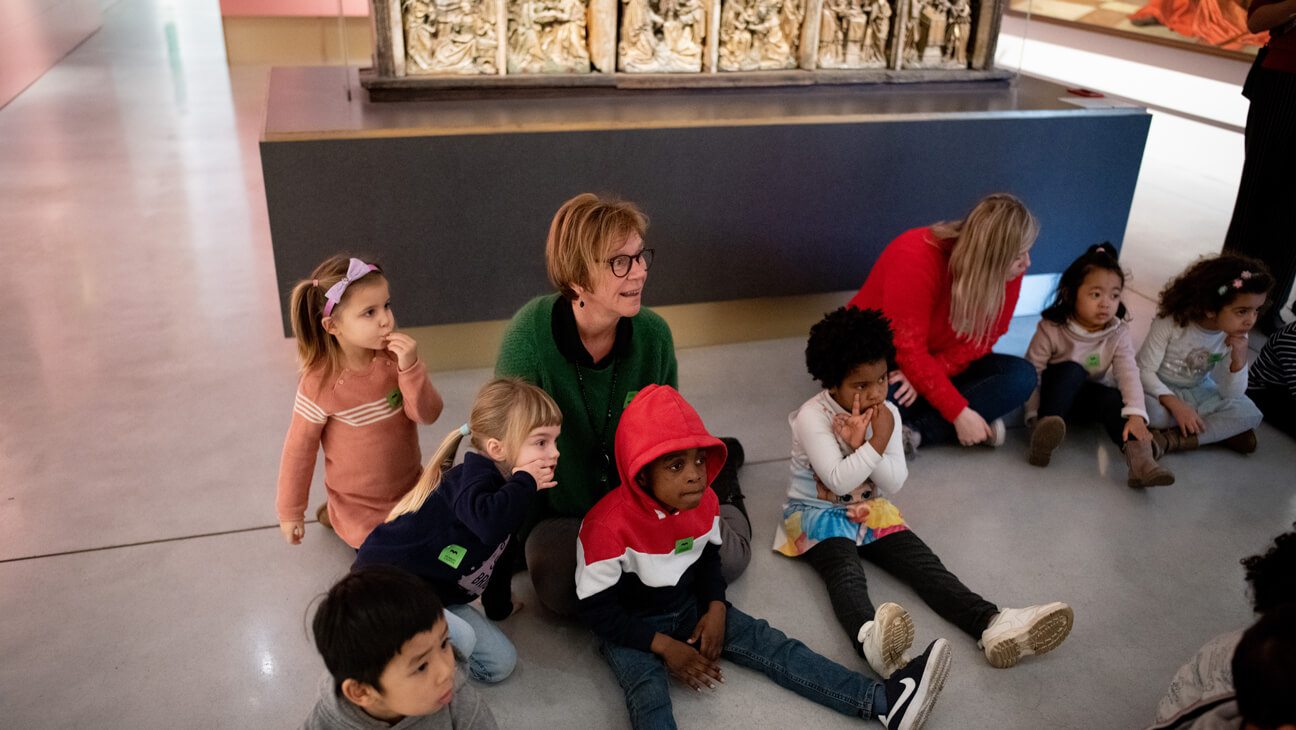 Kleuters kijken naar kunstwerken tijdens klasbezoek aan Museum M in Leuven