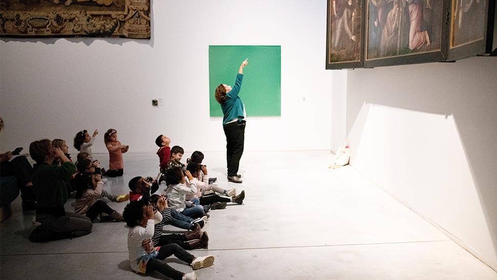 Kinderen kijken door een verrekijkertje naar een schilderij in M-Museum Leuven