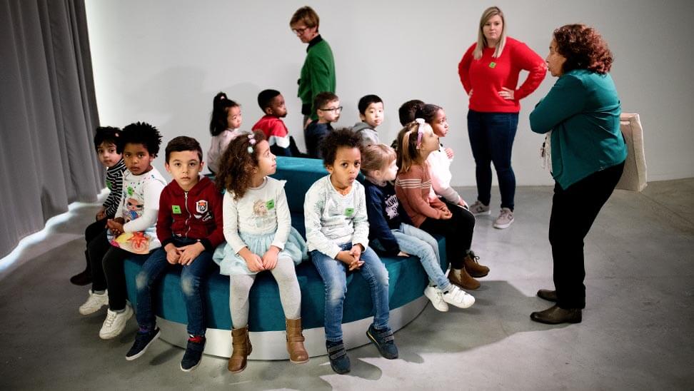 Kinderen zitten bij elkaar in M-Museum Leuven