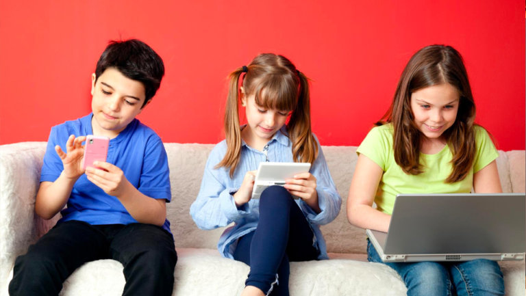 kinderen op een bank met laptop of smartphone