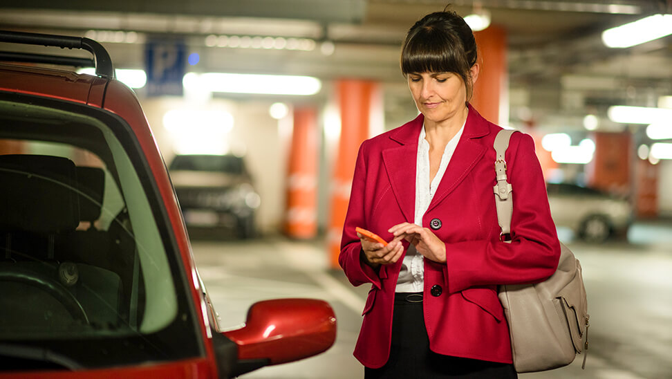 Vrouw met gsm in parkeergarage