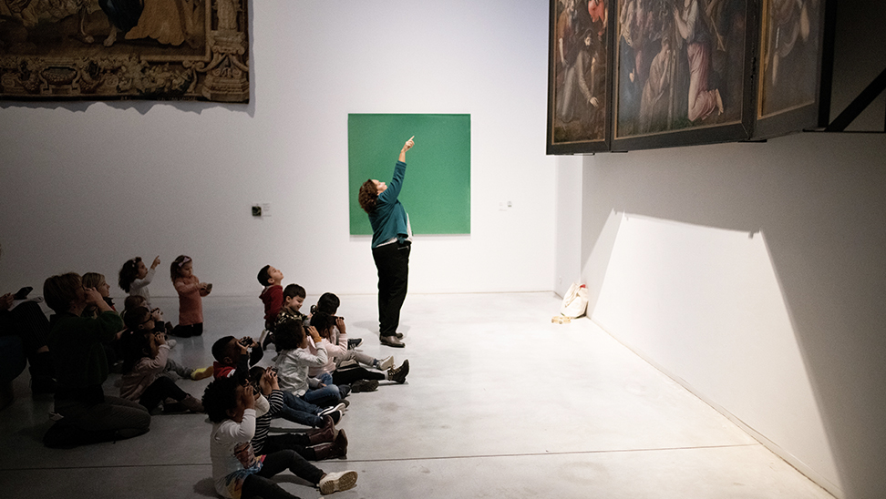 Kinderen kijken door een verrekijkertje naar een schilderij in M-Museum Leuven