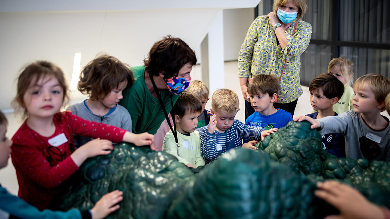 Kinderen verzamelen aan de grote malachiet, een groene edelsteen in het Africamuseum