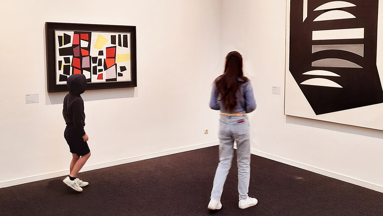 2 kinderen kijken naar schilderij op de expo 'van privé naar publiek'