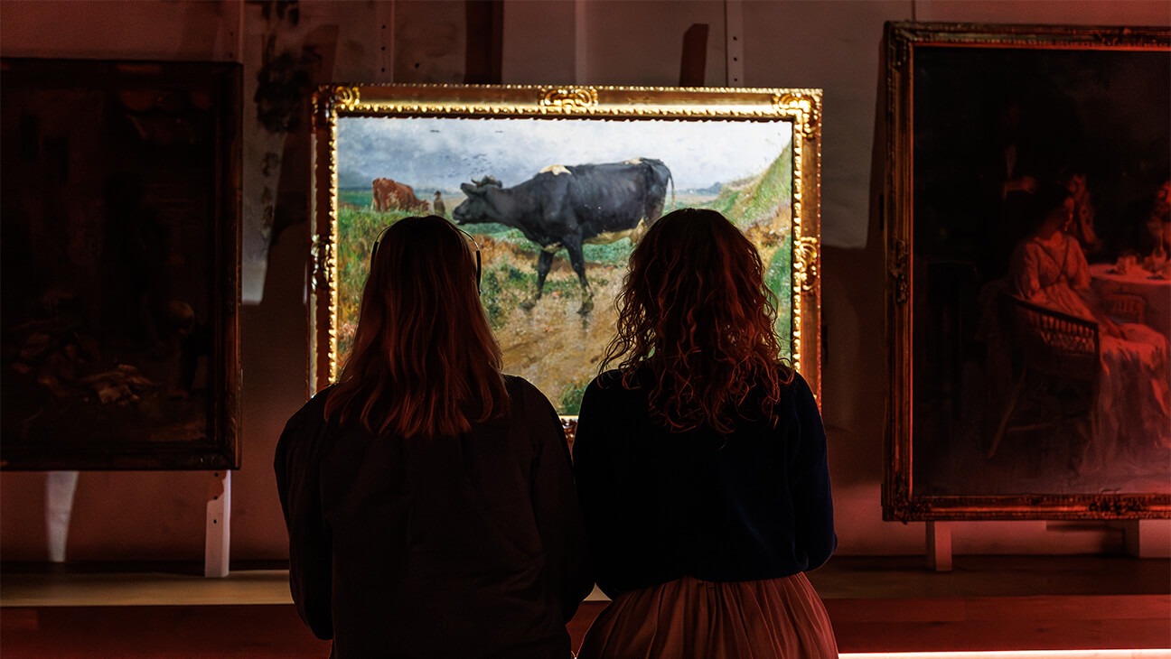 Bezoekers kijken naar een schilderij in Het Kunstuur 