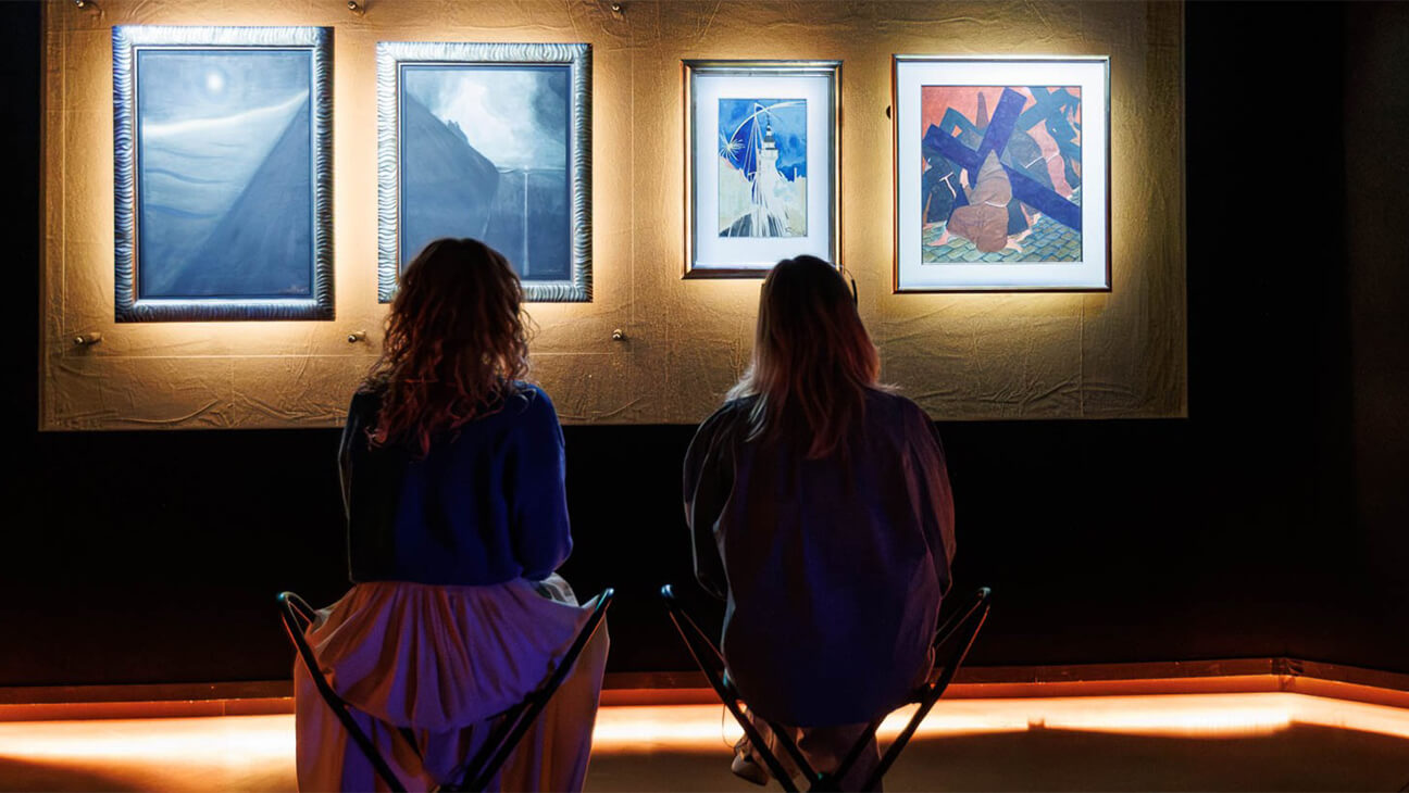 Bezoekers kijken naar een schilderij in Het Kunstuur 