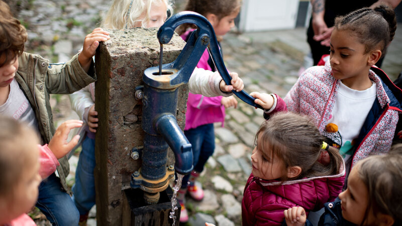 Kinderen bij een oude waterpomp