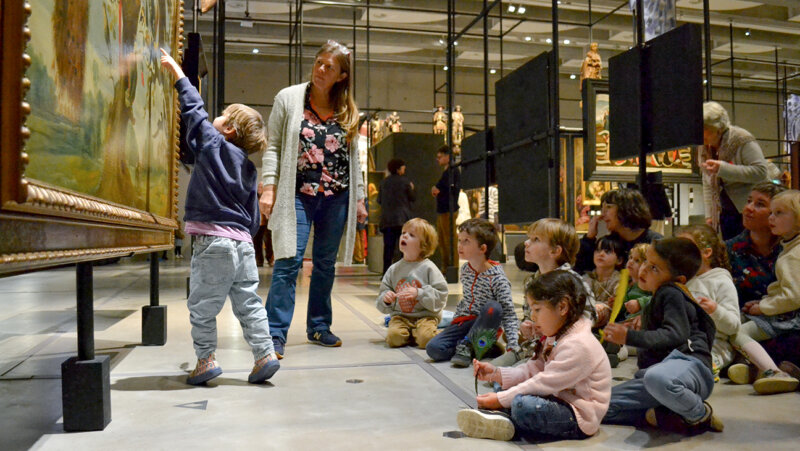 Kinderen kijken naar kunst in de expo 'verborgen parels'
