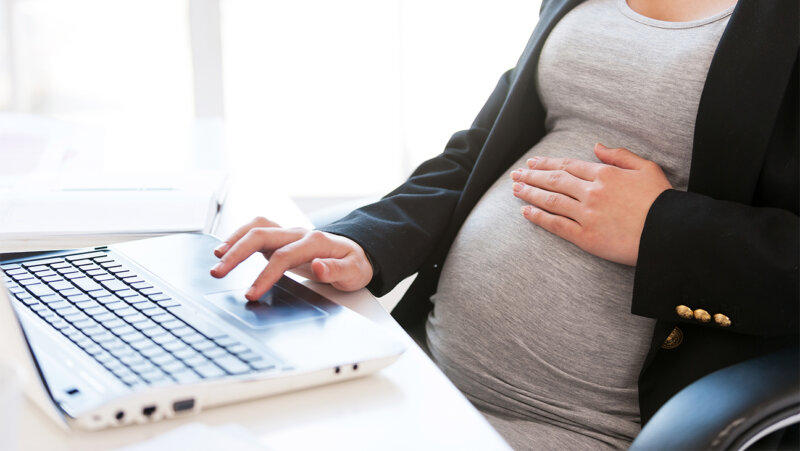 Zwangere vrouw werkt op laptop
